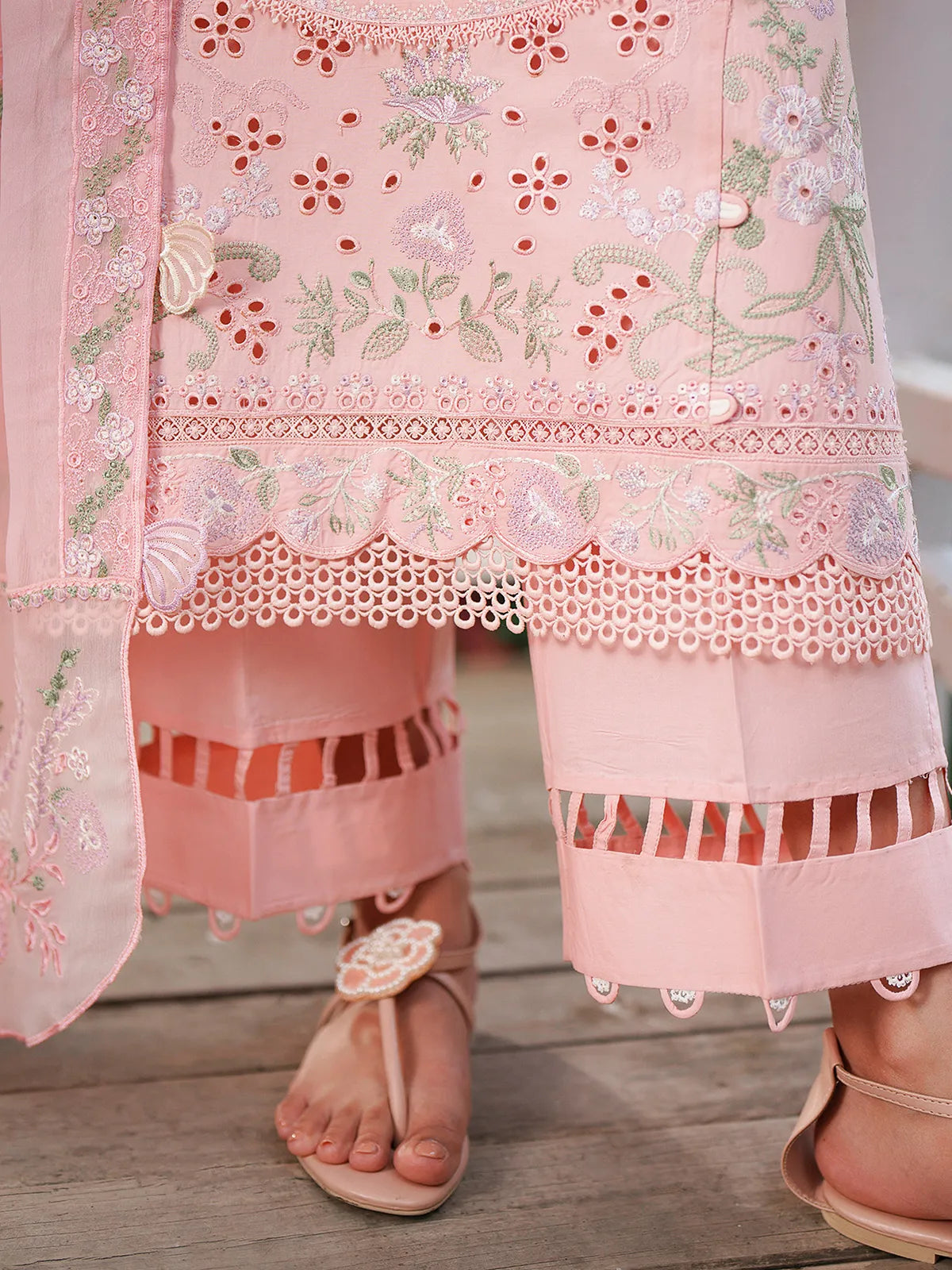 Close-up hem and trouser detail of pink lawn stitched 3-piece suit featuring scalloped eyelet embroidery on daman and cutwork trouser cuffs from Baad-e-Saba by INEJ.