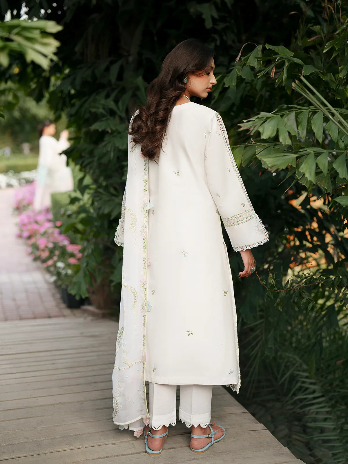 Back full-length view of off-white lawn stitched 3-piece suit featuring embroidered dupatta drape, lace-trimmed sleeve cuffs, and scalloped cutwork trouser cuffs from Baad-e-Saba by INEJ.