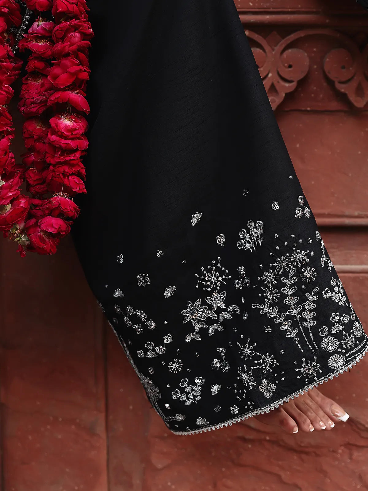 Detailed close-up of silver embroidered trouser hemline on black luxury silk suit from Khat by INEJ.