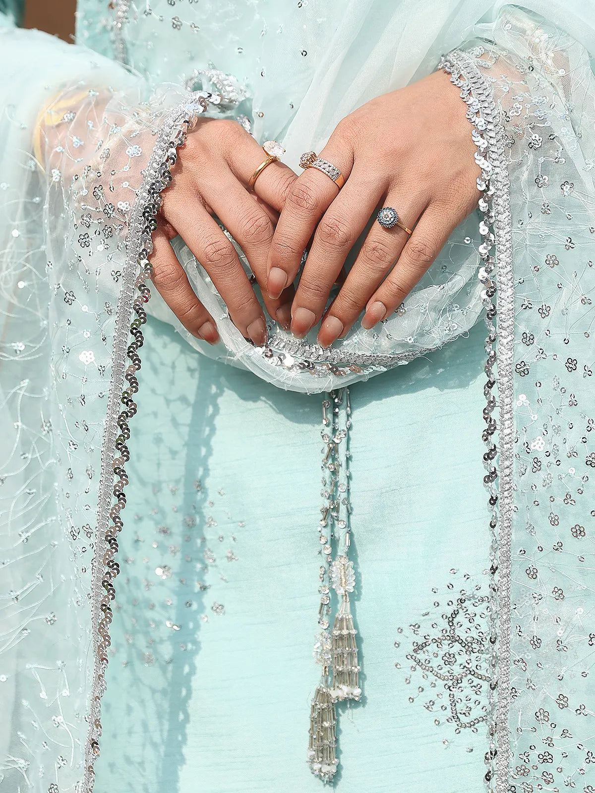 Close-up view of dupatta border lace and tassel neck ties on ice blue luxury silk suit from Khat by INEJ.