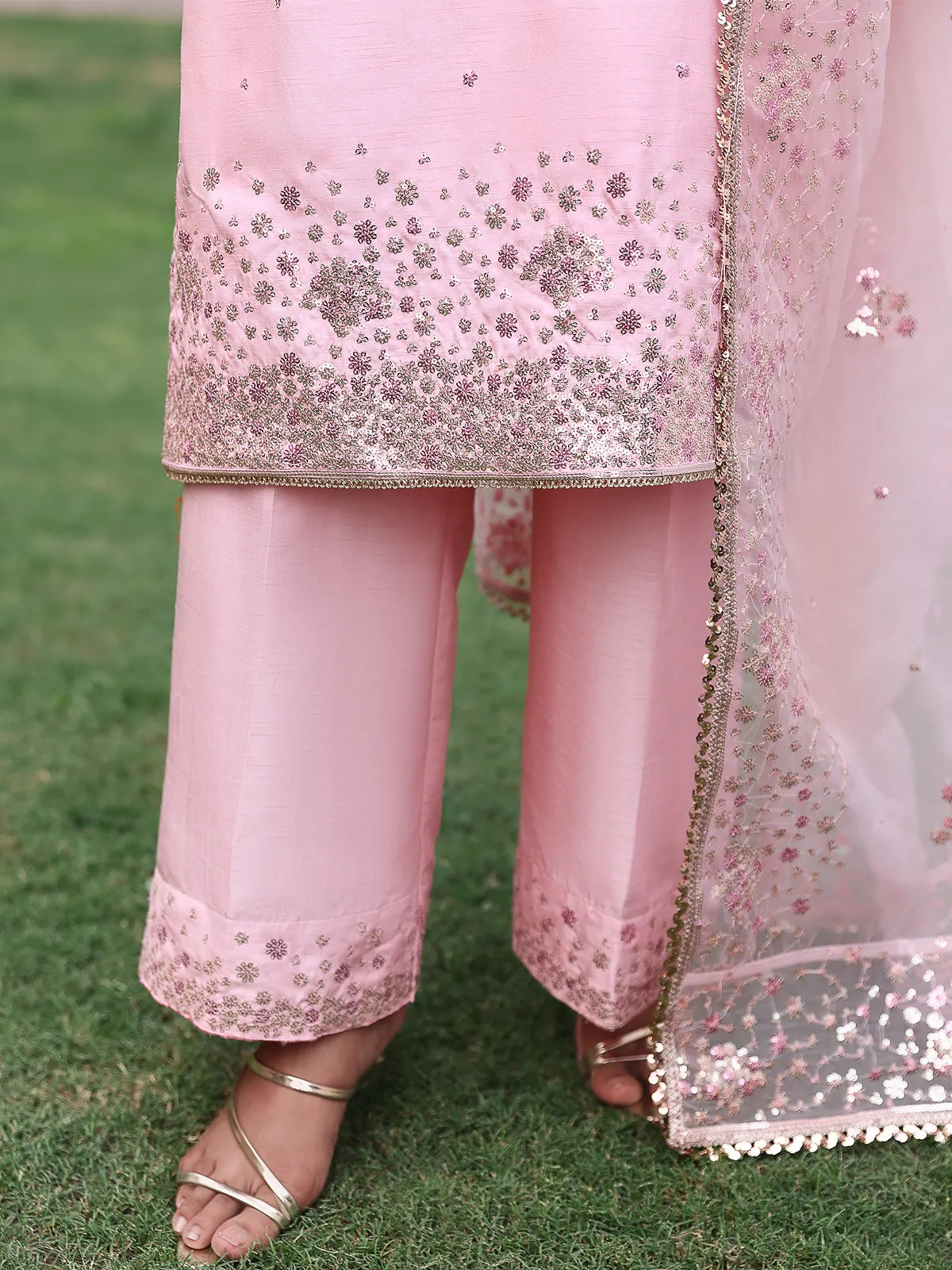 Close-up view of embroidered shirt daman and straight trouser hem on pink luxury silk suit from Khat by INEJ.