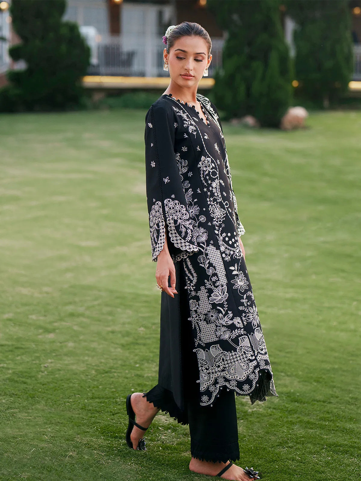 Side profile view of black lawn stitched 3-piece suit showcasing side embroidery and cutwork hem from Baad-e-Saba by INEJ.
