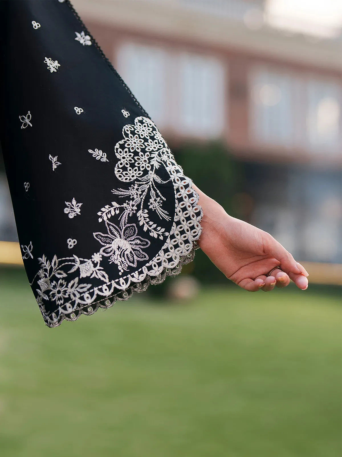 Close-up sleeve detail of black lawn stitched 3-piece suit with intricate cutwork embroidery from Baad-e-Saba by INEJ.