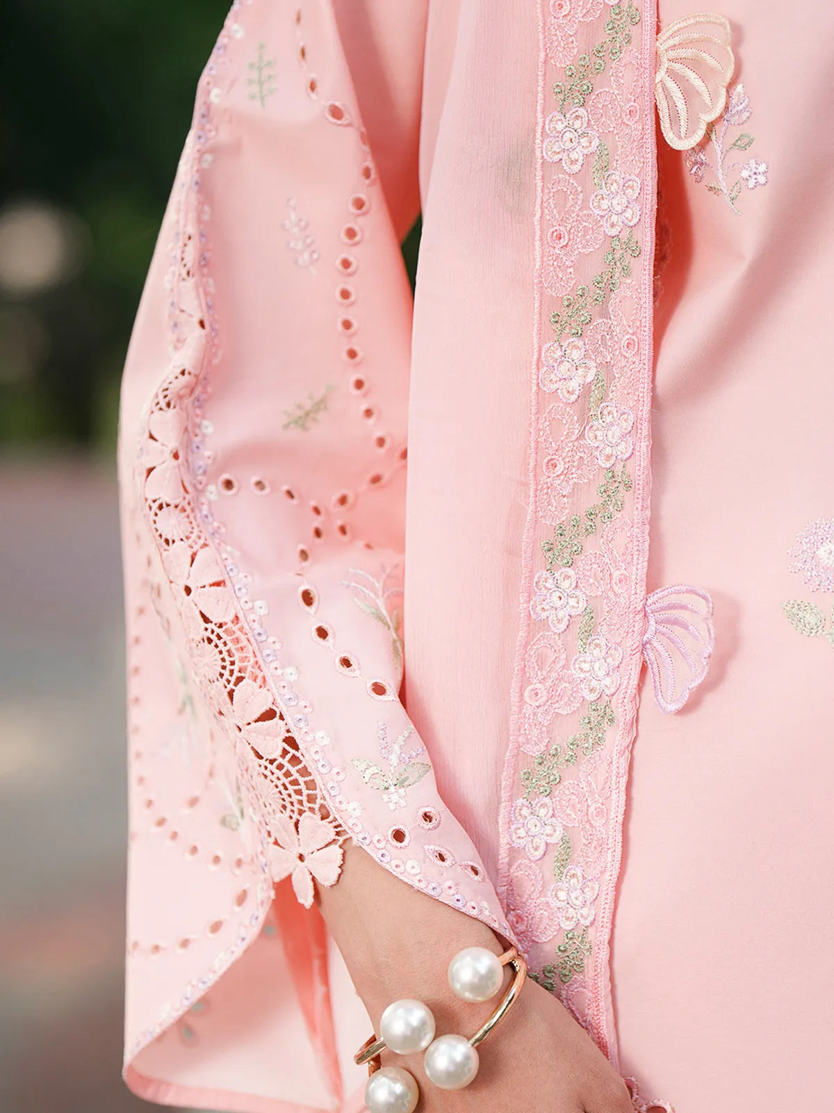 Close-up sleeve and neckline detail of pink lawn stitched 3-piece suit featuring eyelet cutwork sleeves, embroidered neckline, and 3D flower appliqué details on dupatta from Baad-e-Saba by INEJ.