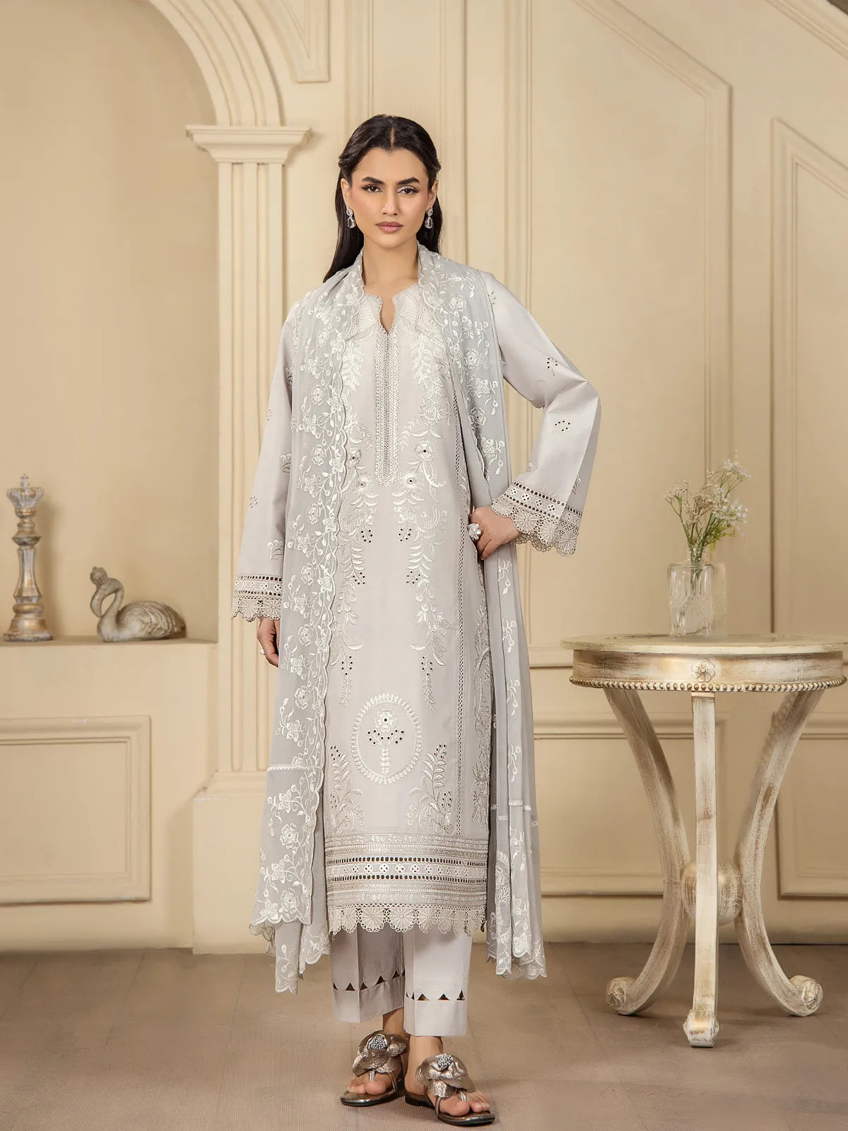 Full front view of a model wearing a light grey 3-piece embroidered lawn suit with matching embroidered dupatta and cut-out trousers by INEJ.