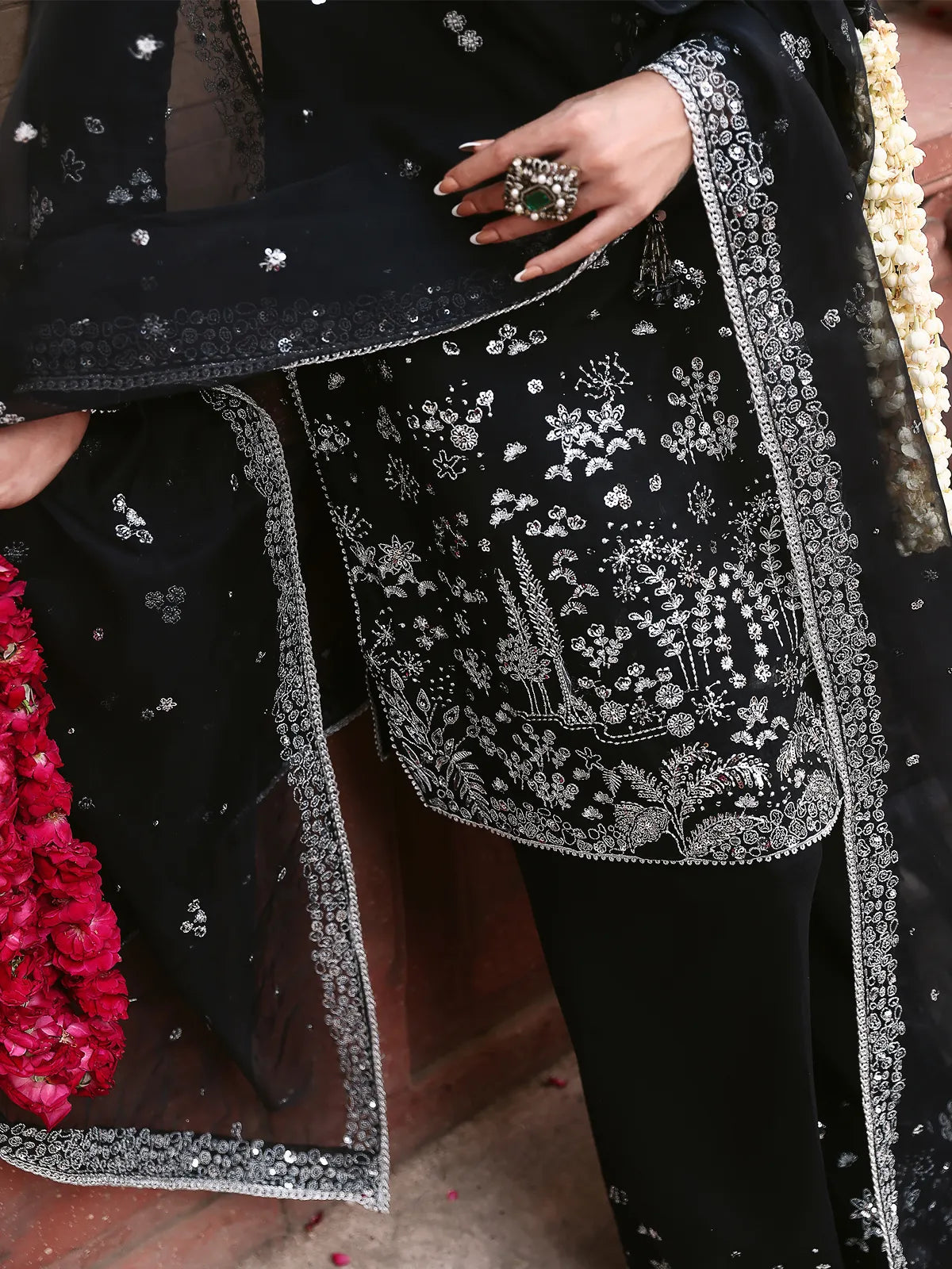 Close-up view of silver embroidered shirt daman and embellished dupatta border on black luxury silk suit from Khat by INEJ.