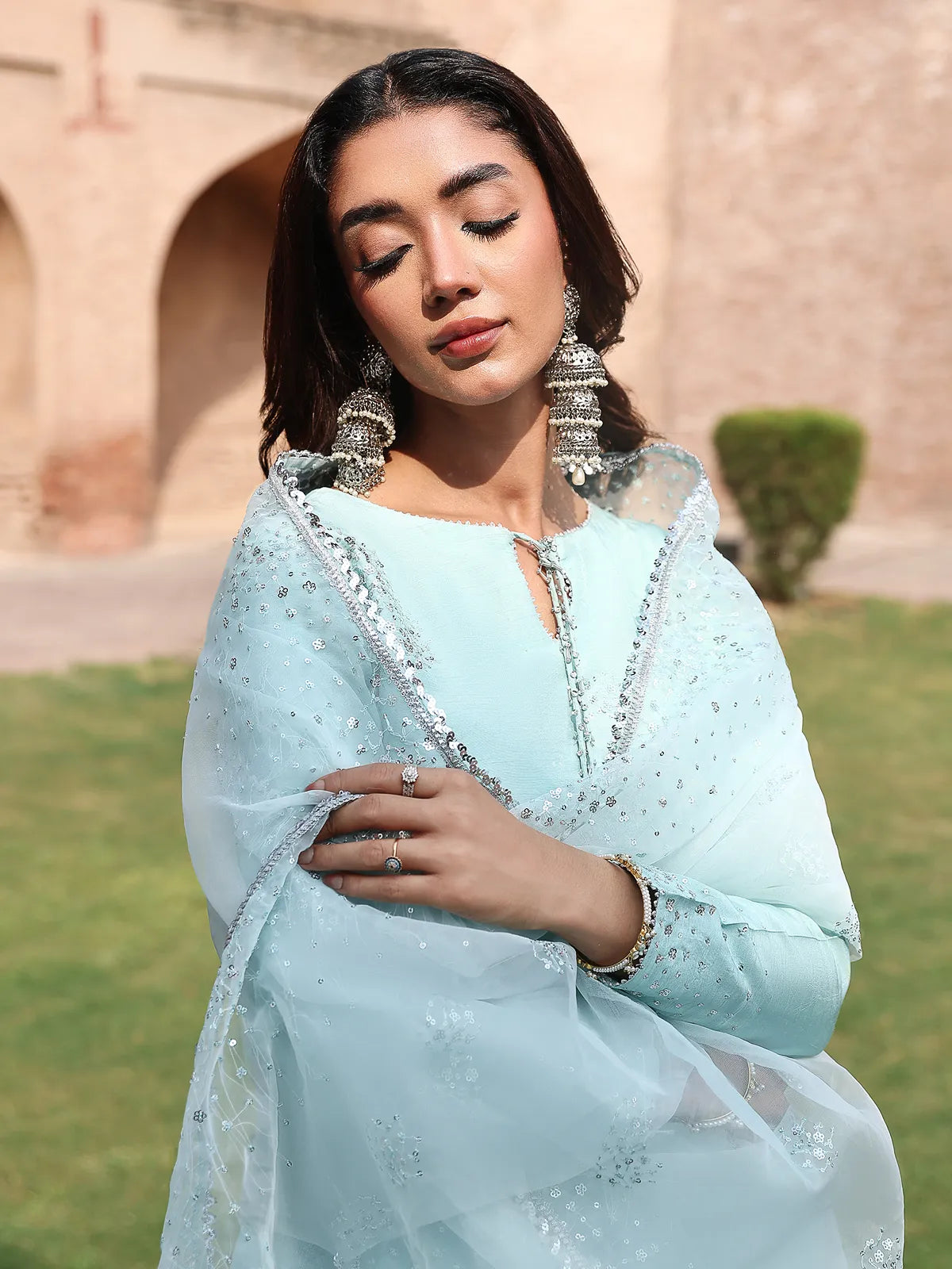 Front portrait view of ice blue luxury silk suit showcasing keyhole neckline and hanging tassels from Khat by INEJ.