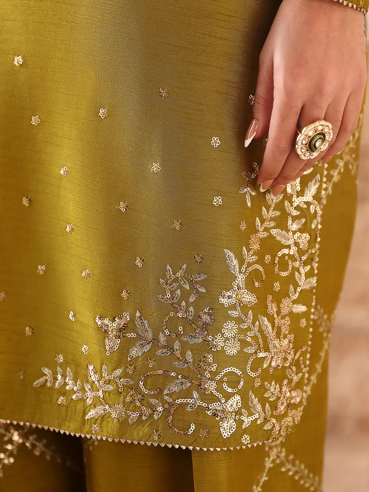 Detailed close-up of silver sequin embroidered daman corner on olive green silk suit from Khat by INEJ.
