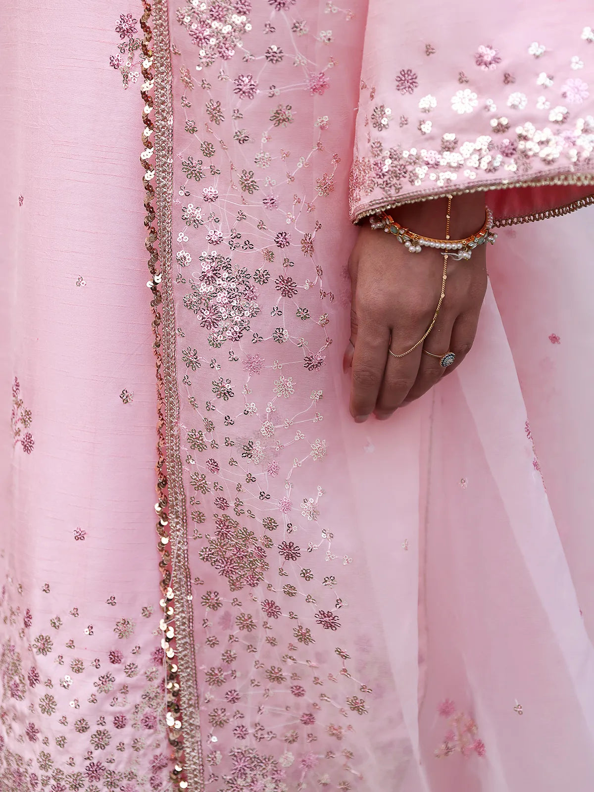 Close-up view of sequin floral sleeve cuff and lace-trimmed dupatta border on pink silk suit from Khat by INEJ.