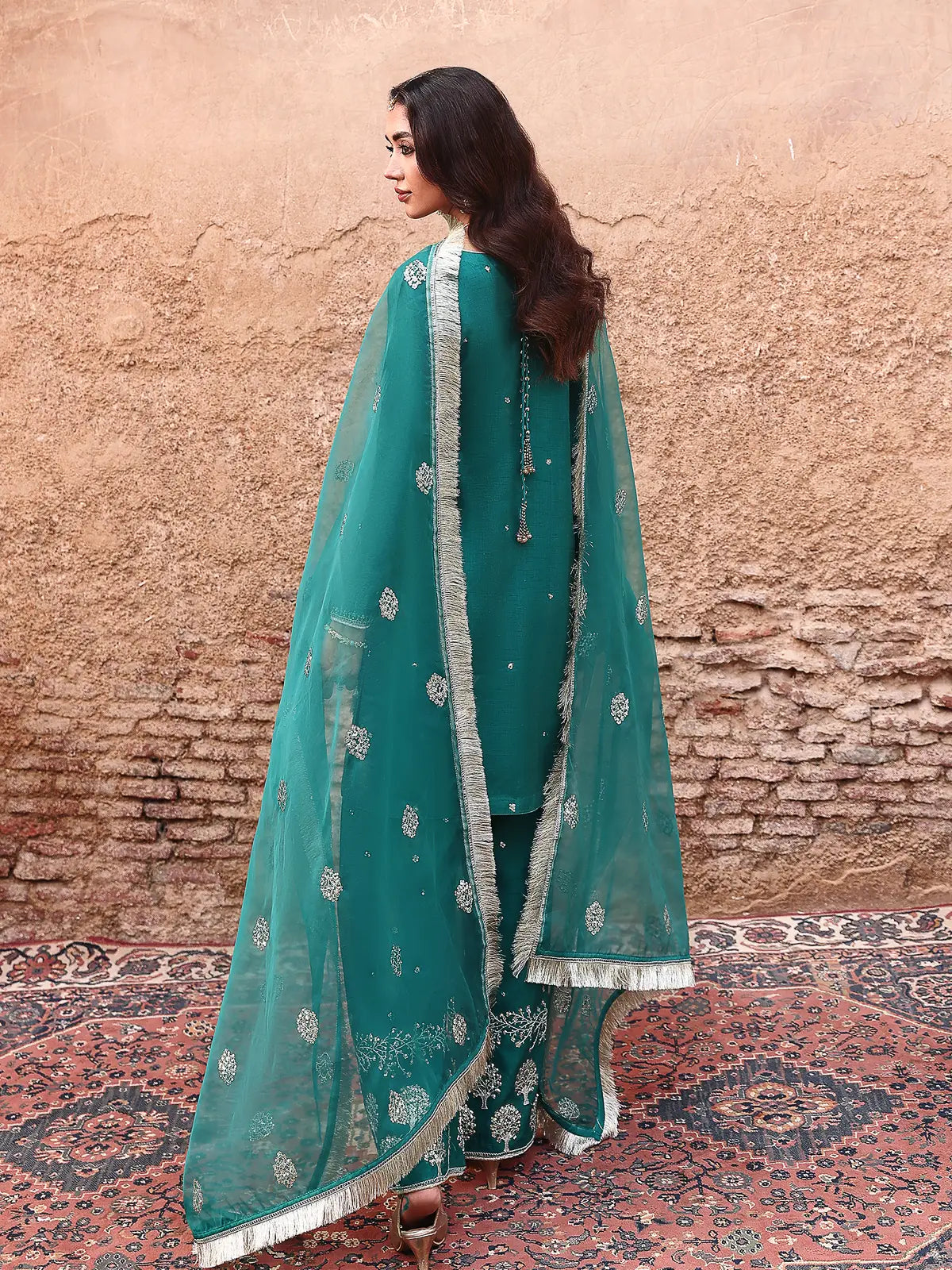 Back full-length view of teal stitched 3-piece luxury silk suit with draped organza dupatta from Khat by INEJ.
