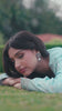Video reel portrait of a model lying on garden grass wearing a powder blue embroidered suit from the Bad-e-Saba collection by INEJ.