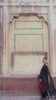 Video reel of a model walking in front of a traditional arched wall wearing the Siyah black embroidered suit set from the Khat collection by INEJ.