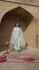 Video reel showing a model in the Aasmani light ice blue embroidered raw silk suit with an organza dupatta standing under a heritage archway from the Khat collection by INEJ.